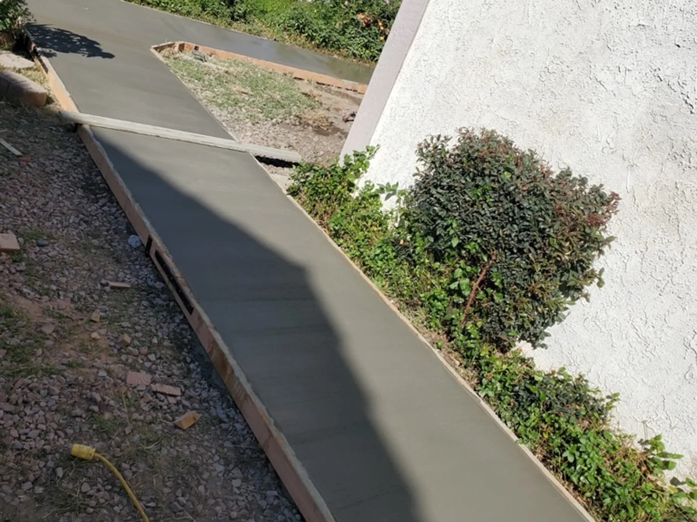 After: Finished concrete side walkway running along the house